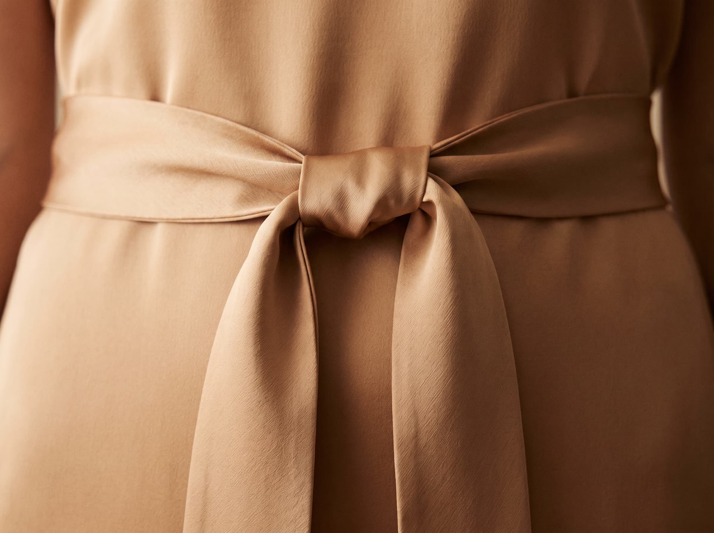 La ceinture de la robe Zellige en amande, coupée en biais et nouée à plat.