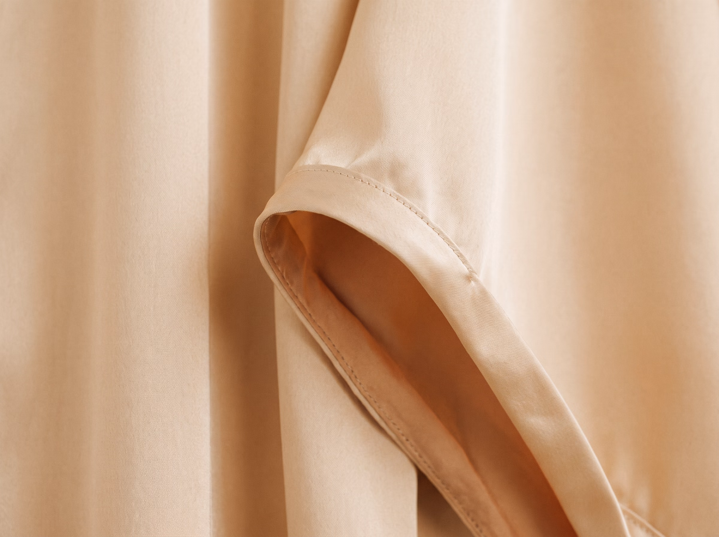 L’ourlet roulé de la robe Zellige en amande, et la couture de doublure.